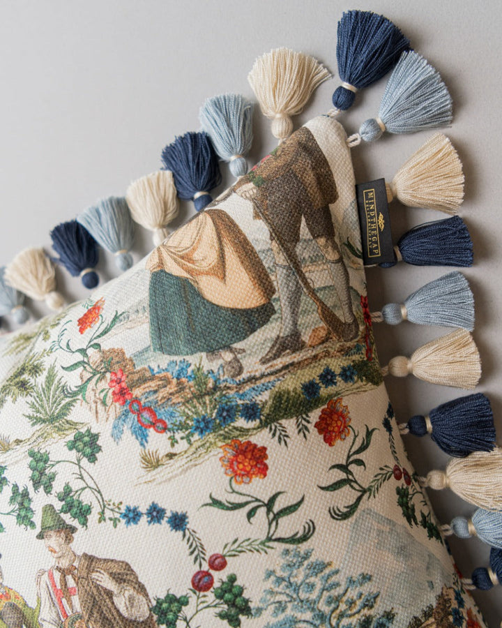 LANDHAUSMODE Cushion (LC40197) by Mind The Gap | LC40197 | TYROL APRES-SKI | 50 x 50 cm | Blue, White, Green, Red | Fringes all around | Duck feather | 56% Cotton, 44% Linen | Fabric Carolina | https://www.fabriccarolina.com/