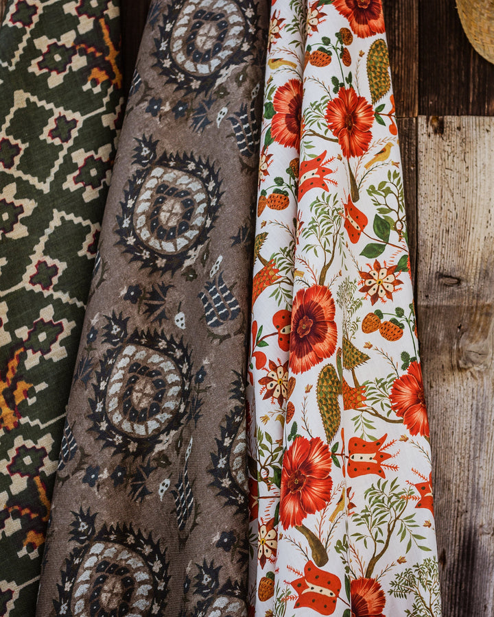 Szekely Folk linen fabric by Mind the Gap (FB00040), draped with coordinating fabrics